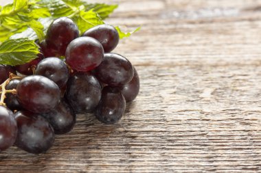 Olgun karanlık üzüm yaprakları, ahşap arka plan ile. Selectiva odak. Kopya alanı.