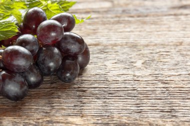 Olgun karanlık üzüm yaprakları, ahşap arka plan ile. Selectiva odak. Kopya alanı.