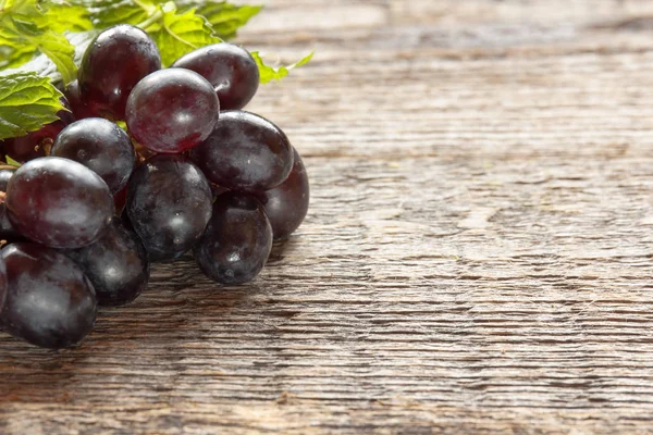 Olgun karanlık üzüm yaprakları, ahşap arka plan ile. Selectiva odak. Kopya alanı.