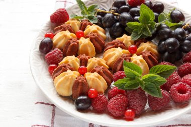 Beyaz plaka üzerinde taze çilek ile bisküvi. Seçici odak.