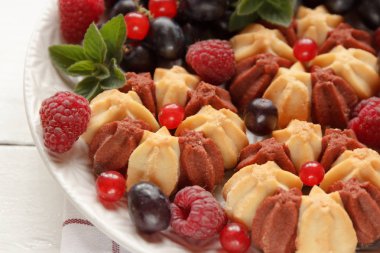 Beyaz plaka üzerinde taze çilek ile bisküvi. Seçici odak.