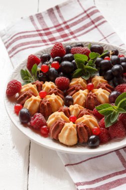 Beyaz plaka üzerinde taze çilek ile bisküvi. Seçici odak.