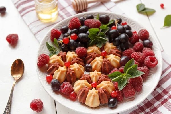 Beyaz plaka üzerinde taze çilek ile bisküvi. Seçici odak.