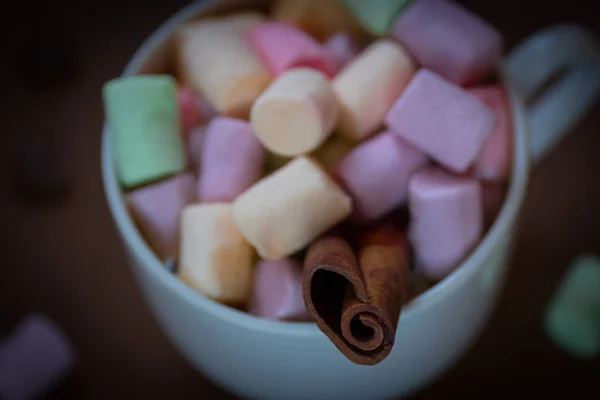 Chocolate quente em uma xícara branca com marshmallows coloridos em um fundo escuro. Foco seletivo . — Fotografia de Stock