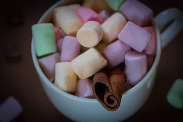 Chocolate quente em uma xícara branca com marshmallows coloridos em um fundo escuro. Foco seletivo . — Fotografia de Stock