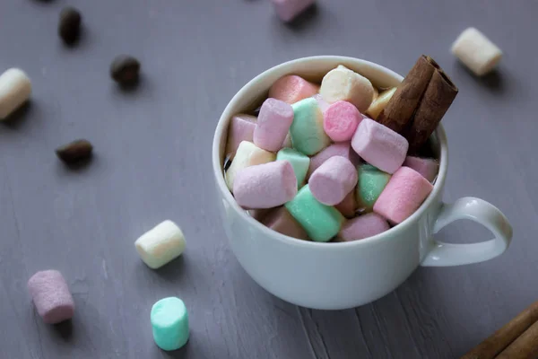 Chocolate quente em uma xícara branca com marshmallows coloridos em um fundo escuro. Foco seletivo . — Fotografia de Stock