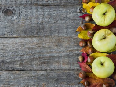 Sonbahar arka plan ile kuru yaprakları, fındık, meşe palamutları tarçın baharat ahşap masa üzerinde. Kopya alanı
