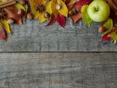 Sonbahar arka plan ile kuru yaprakları, fındık, meşe palamutları tarçın baharat ahşap masa üzerinde. Kopya alanı