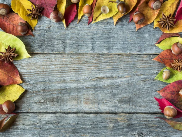 Herbst Hintergrund mit trockenen Blättern, Nüssen, Eicheln Zimt Gewürze auf Holztisch. Kopierraum — Stockfoto