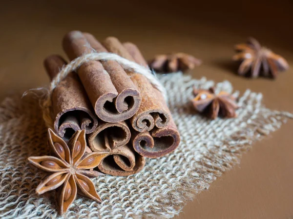 Laski cynamonu połączone przez ciąg na płótnie brązowe drewniane tła — Zdjęcie stockowe