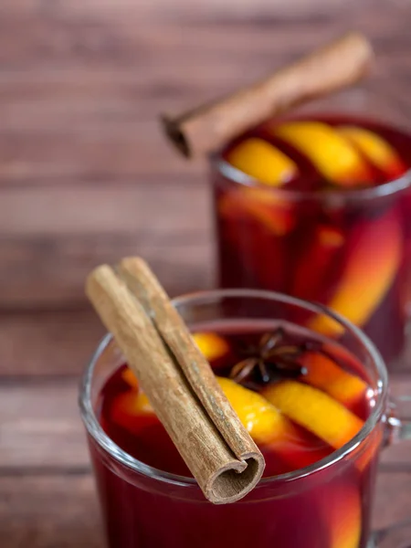 Glass Cup of red wine mulled wine on a wooden background with cinnamon spices and orange. Selective focus — Stock Photo, Image