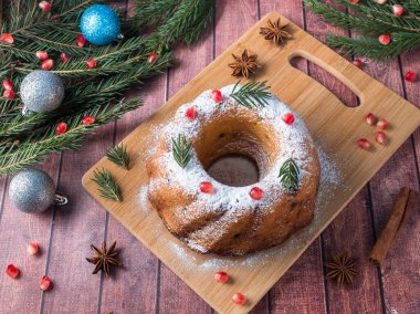 Christmas cake Noel süslemeleri ile bir çelenk şeklinde. Nar anason yıldızlı köknar ağacı dalları.