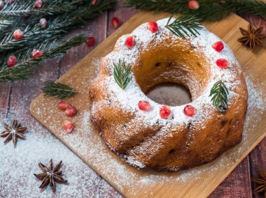 Christmas cake Noel süslemeleri ile bir çelenk şeklinde. Nar anason yıldızlı köknar ağacı dalları.