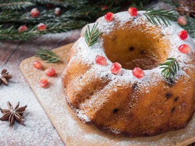 Christmas cake Noel süslemeleri ile bir çelenk şeklinde. Nar anason yıldızlı köknar ağacı dalları.