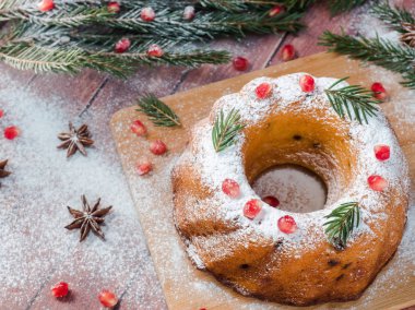 Christmas cake Noel süslemeleri ile bir çelenk şeklinde. Nar anason yıldızlı köknar ağacı dalları.