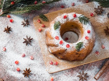 Christmas cake Noel süslemeleri ile bir çelenk şeklinde. Nar anason yıldızlı köknar ağacı dalları.