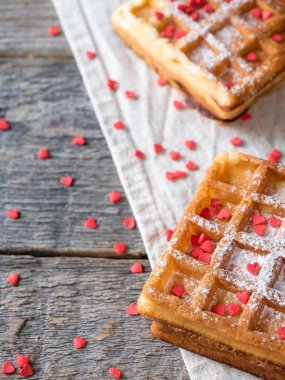 Pudra şekeri ve rustik ahşap arka plan kopya alanı üzerinde kırmızı kalpler ile yumuşak Viyana Belçika waffle