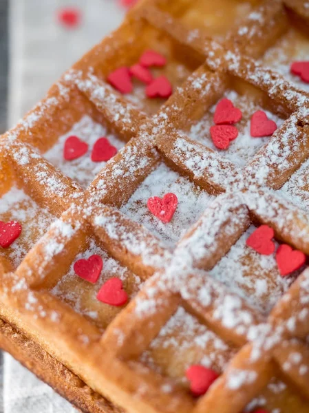 Gaufres belges viennoises douces avec sucre en poudre et coeurs rouges sur fond de bois rustique — Photo