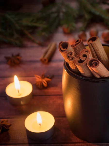 Black ceramic Cup with cinnamon on dark wooden table with candles — Stock Photo, Image