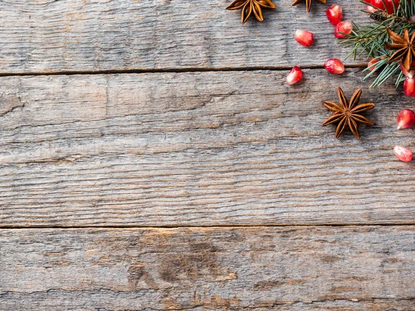 Гранат ель ветви звезды анисовые орехи, корица и зимние специи на деревянном фоне, сельский стиль — стоковое фото