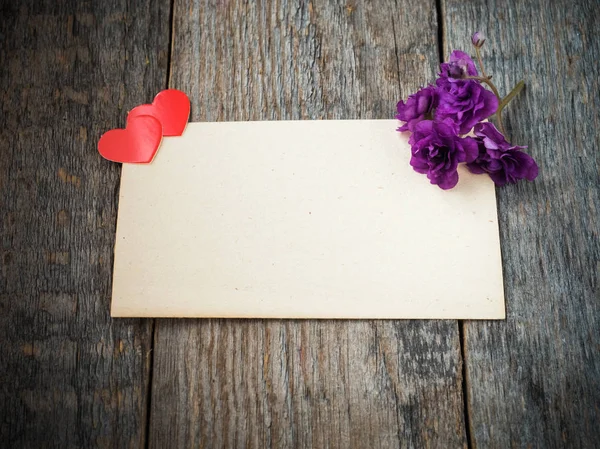 Kağıt kalp ve eski bir rustik ahşap zemin üzerine kağıt üzerine Menekşe çiçek