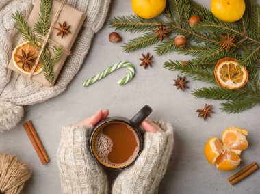 Bir fincan sıcak çikolata bir gri beton zemin mandalina sahne üzerinde tutan bir kazaklı kış sıcak içecek kadın eller