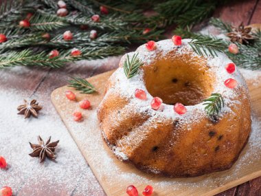 Christmas cake Noel süslemeleri ile bir çelenk şeklinde. Nar anason yıldızlı köknar ağacı dalları.