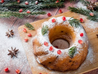 Christmas cake Noel süslemeleri ile bir çelenk şeklinde. Nar anason yıldızlı köknar ağacı dalları.