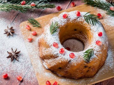 Christmas cake Noel süslemeleri ile bir çelenk şeklinde. Nar anason yıldızlı köknar ağacı dalları.