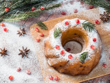 Christmas cake Noel süslemeleri ile bir çelenk şeklinde. Nar anason yıldızlı köknar ağacı dalları.