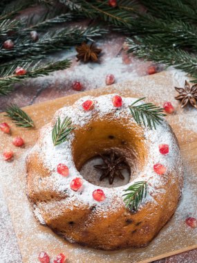 Christmas cake Noel süslemeleri ile bir çelenk şeklinde. Nar anason yıldızlı köknar ağacı dalları.