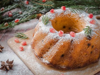 Christmas cake Noel süslemeleri ile bir çelenk şeklinde. Nar anason yıldızlı köknar ağacı dalları.