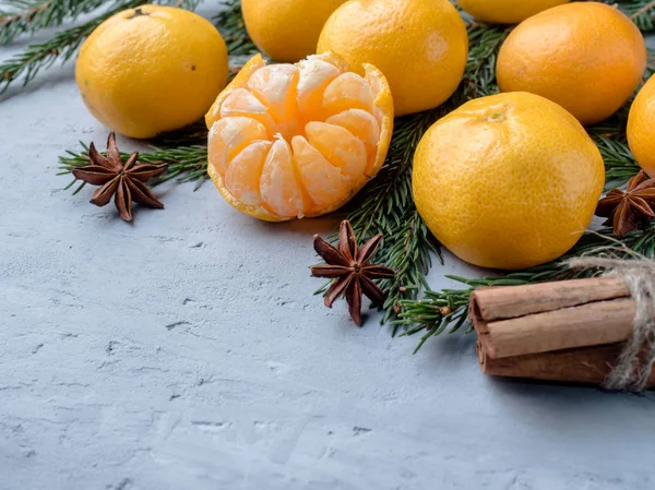 Frische Mandarinen mit Zweigen vom Weihnachtsbaum, Sternanis Zimt auf grauem Betonhintergrund Kopierraum — Stockfoto