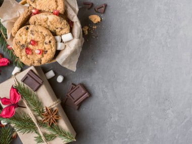 Noel hediye Paketli kağıt ve bir plaka, Çerezler çikolata beton arka plan kopya alanı