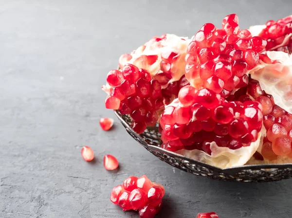 Peeled juicy red garnet vintage plate in rustic style, selective focus — Stock Photo, Image