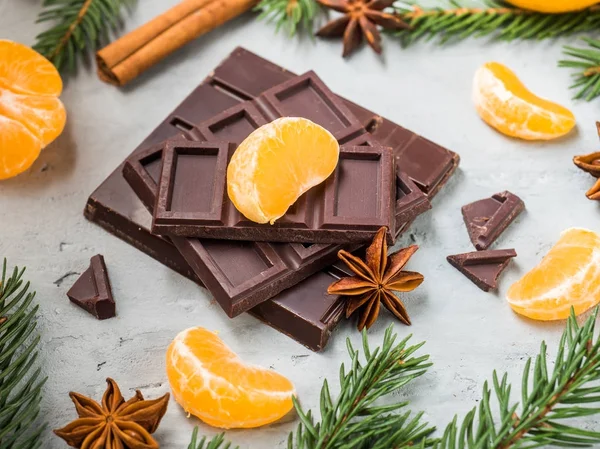 Tangerinas frescas com ramos de árvore de Natal, estrela anis canela de chocolate no fundo de concreto cinza — Fotografia de Stock