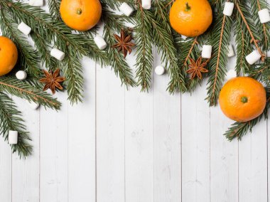 Taze mandalina veya mandalina sapları ve yaprakları üzerinde beyaz ahşap arka plan kopya alanı ile