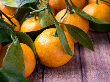 Taze Mandarin veya mandalina ile kaynaklanıyor ve bir kahverengi ahşap arka plan kopya boşluk bırakır