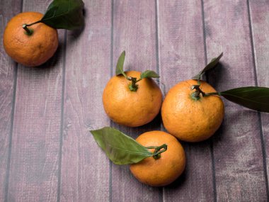 Taze Mandarin veya mandalina ile kaynaklanıyor ve bir kahverengi ahşap arka plan kopya boşluk bırakır