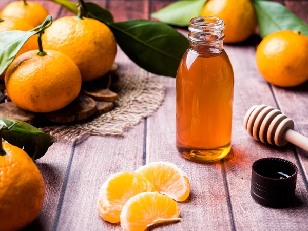 Aromatic tangerine oil, with tangerines on a wooden background, selective focus — Stock Photo, Image