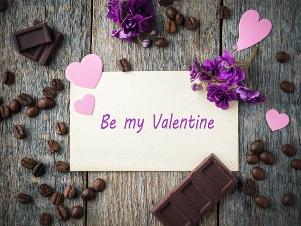 Decorations for Valentines day paper hearts, violets, coffee and chocolate on the old paper and wood background — Stock Photo, Image