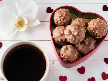 Orkide Beyaz ahşap arka plan çikolata bir kırmızı kalp kahve Kupası