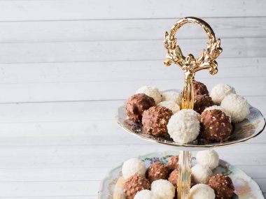 Çikolata ve Hindistan cevizi şeker bir kase ahşap tepsi kahve Kupası orkide.