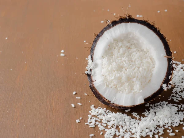 Coco orgânico fresco quebrado em duas partes com coco em um fundo de madeira rústico — Fotografia de Stock