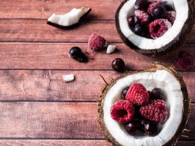 Dondurulmuş çilek ile Hindistan cevizi yarım bir karanlık ahşap arka plan kopya alanı