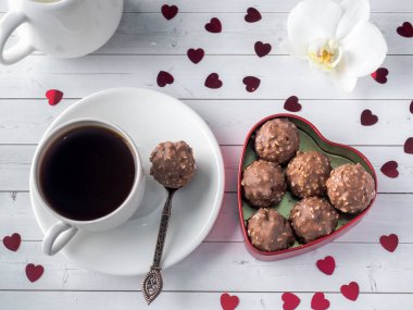 Orkide Beyaz ahşap arka plan çikolata bir kırmızı kalp kahve Kupası