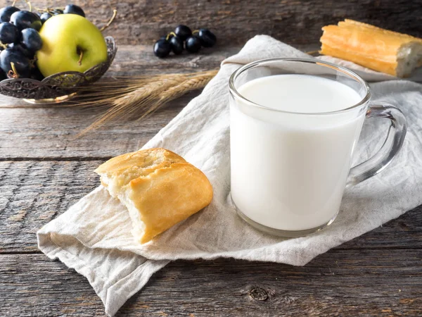 村庄早餐牛奶面包苹果葡萄在毛巾木桌上 — 图库照片