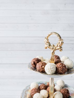 Çikolata ve Hindistan cevizi şeker bir kase ahşap tepsi kahve Kupası orkide.