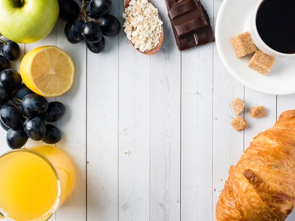 Desayuno en una mesa blanca Café Croissant Zumo de naranja Uvas Chocolate de manzana Copiar espacio para texto — Foto de Stock