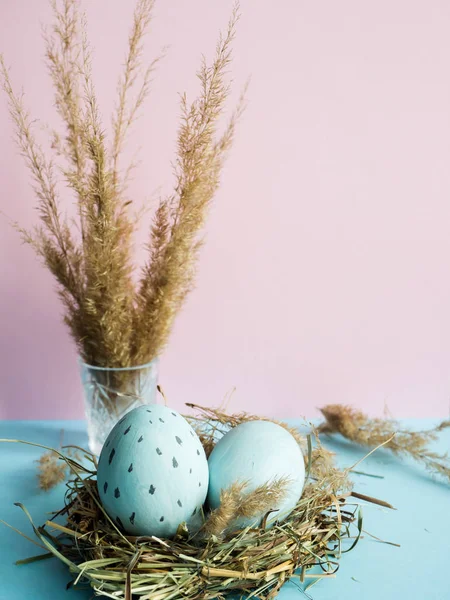 Uova di Pasqua in un nido d'erba. Sfondo rosa . — Foto Stock